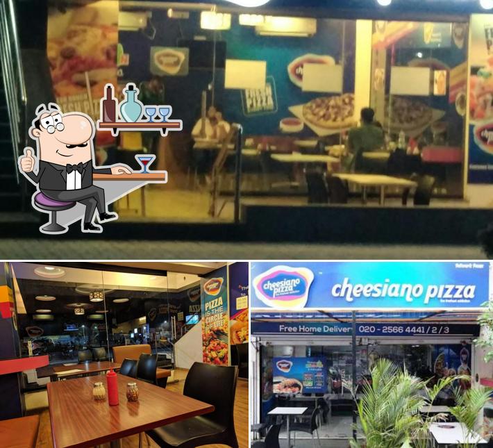 Take a seat at one of the tables at Cheesiano Pizza Baner