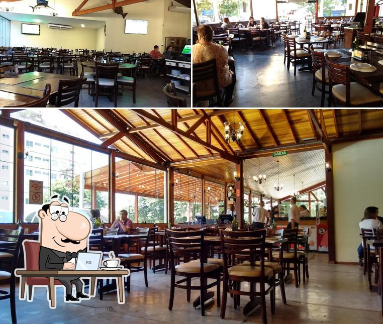 Sente em uma das mesas no Espaço Nobre Restaurante E Pizzaria