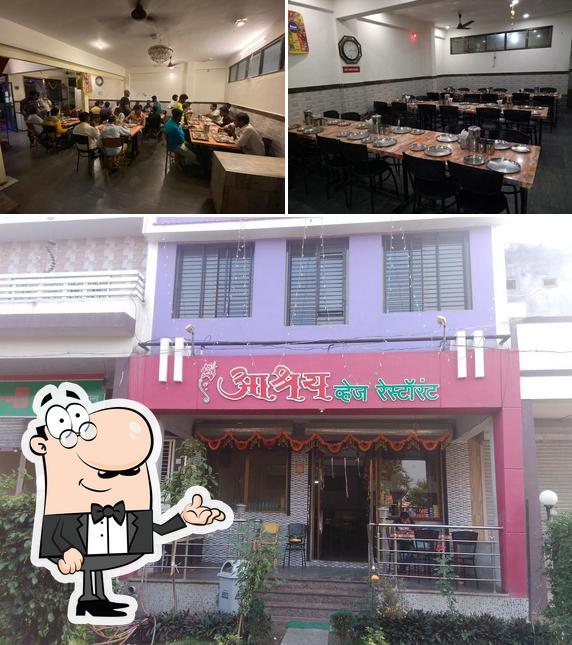 Take a seat at one of the tables at Hotel Aashray Pure Veg Restaurant Best Family Hotel Pure Vegetarian Hotel