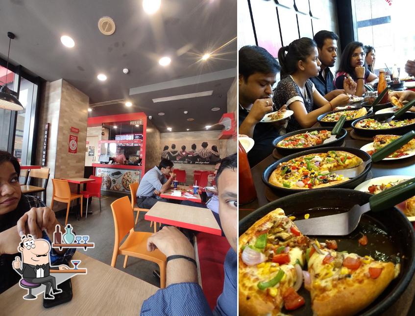 Take a seat at one of the tables at Pizza Hut Cyber Greens, Gurgaon