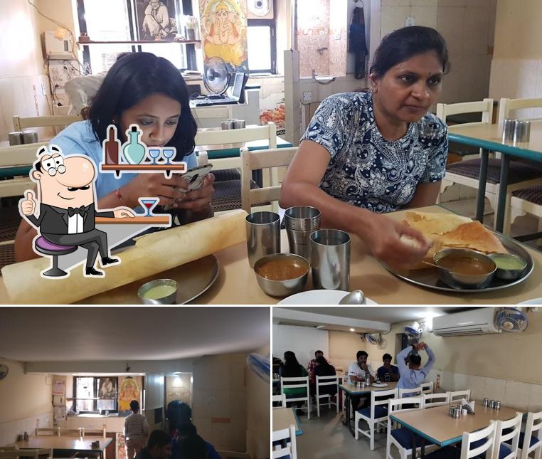 Take a seat at one of the tables at Shivali Restaurant & Dining Hall