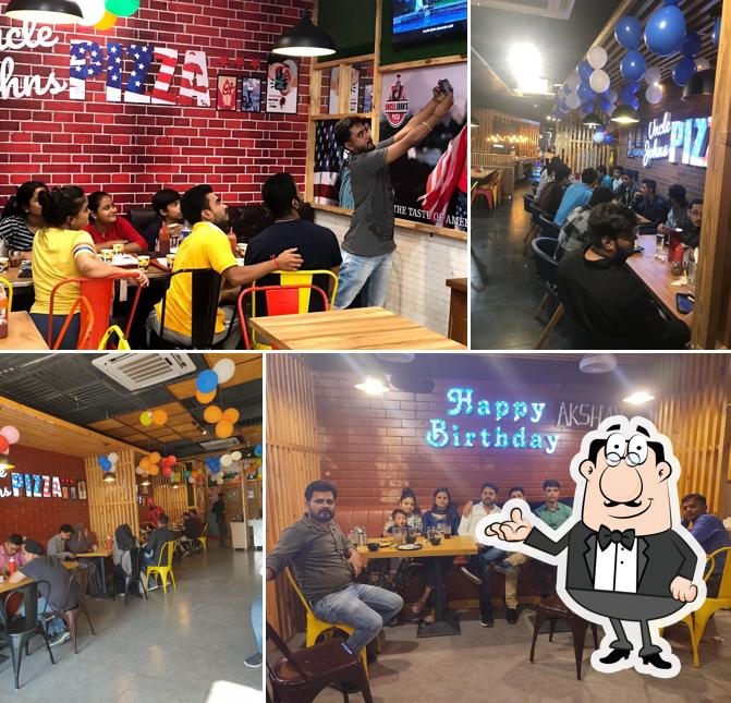 Take a seat at one of the tables at Uncle John's Pizza Kailashpur