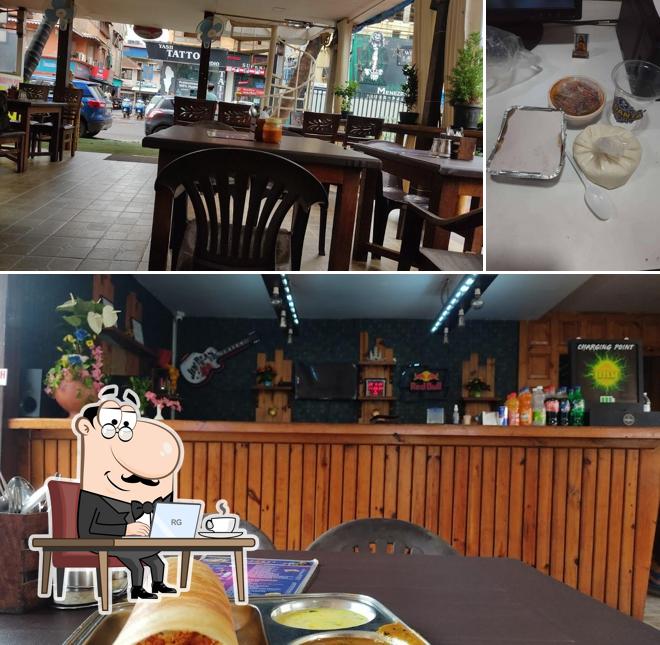 Take a seat at one of the tables at Punjabi Rasoi by Vedanta Pure Veg Family Restaurant