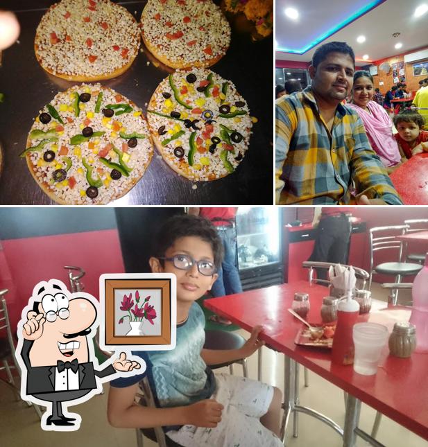 Take a seat at one of the tables at RP PALANPUR PAPRIKA PIZZA (REAL PAPRIKA) AROMA CIRCLE