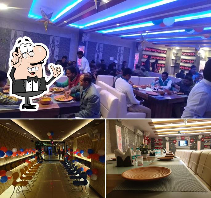 Take a seat at one of the tables at VEG R P Restaurant & HOTEL