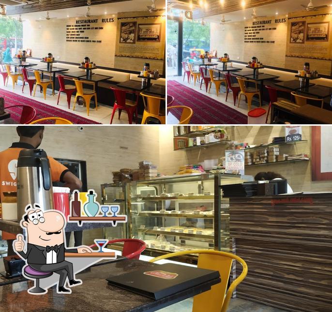 Take a seat at one of the tables at Azad restaurant and corporate sweets (Iskcon)