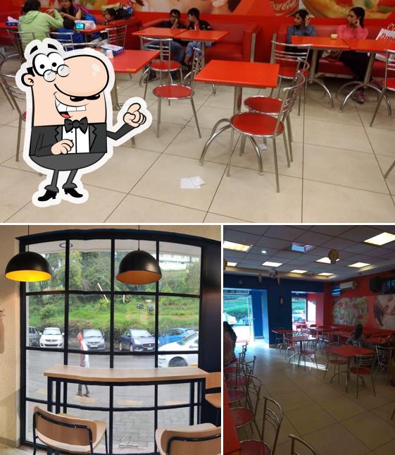Take a seat at one of the tables at Domino's Pizza Ootacamund Town, Ooty