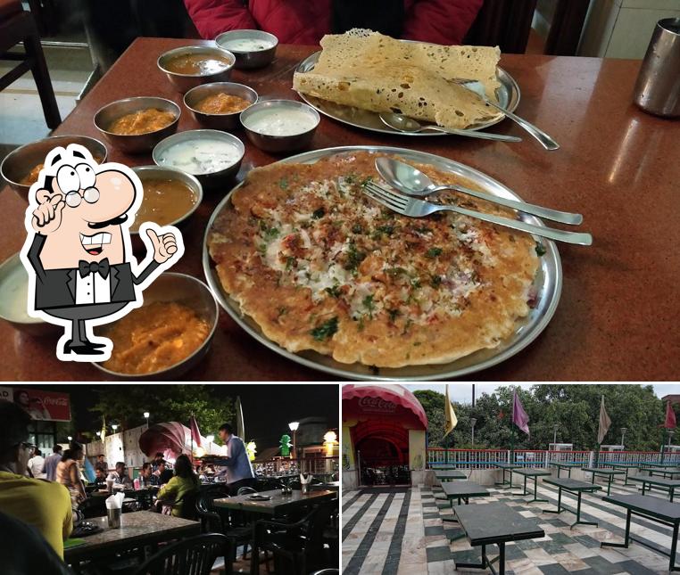 Take a seat at one of the tables at Guruprasad Udupi Restaurant