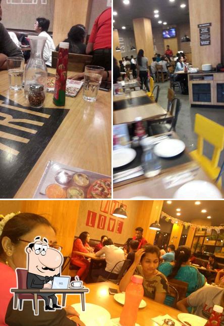 Take a seat at one of the tables at Pizza Hut Kandivili Profit Centre, Mumbai