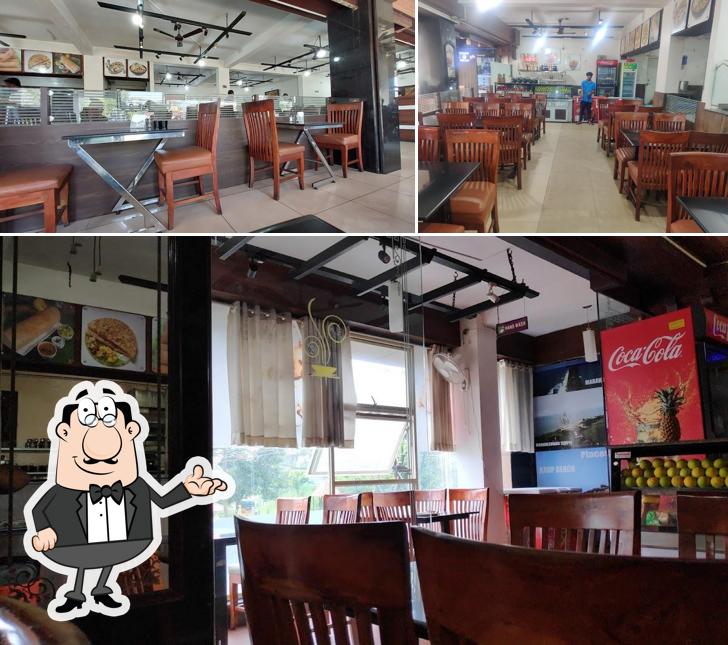 Take a seat at one of the tables at Ambika Upahar Udupi Vegetarian Restaurant