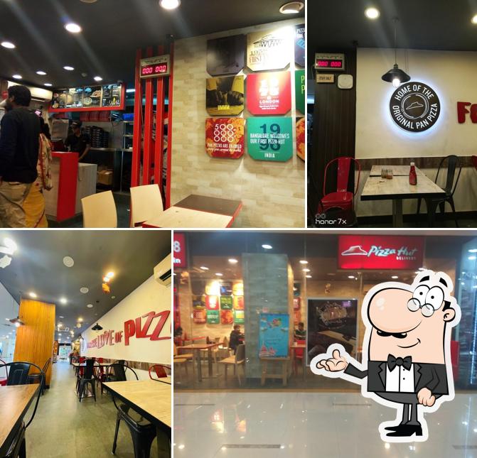 Take a seat at one of the tables at Pizza Hut Cosmos Mall, Ujjain