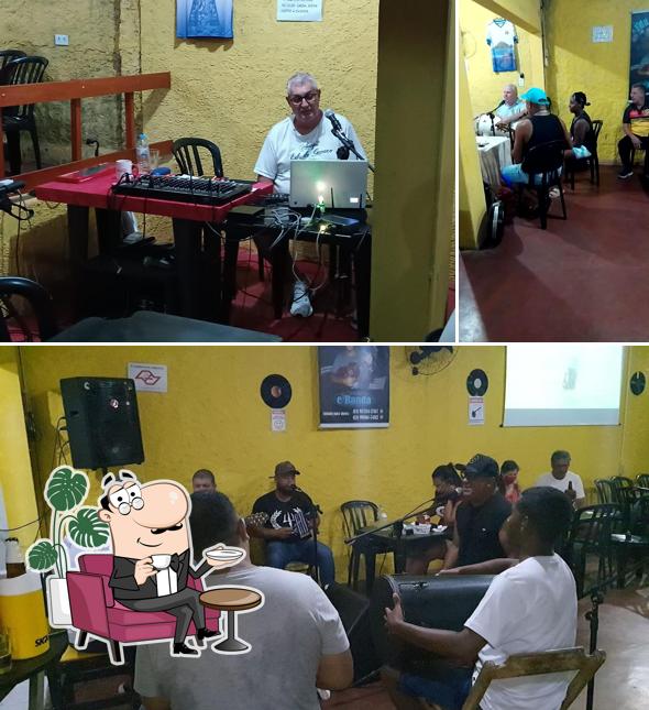 Sente em uma das mesas no Edu Bar & Petiscaria