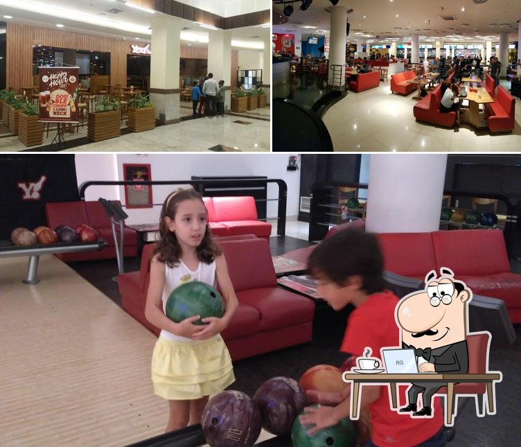 Sente em uma das mesas no Yex Boliche & Steak House