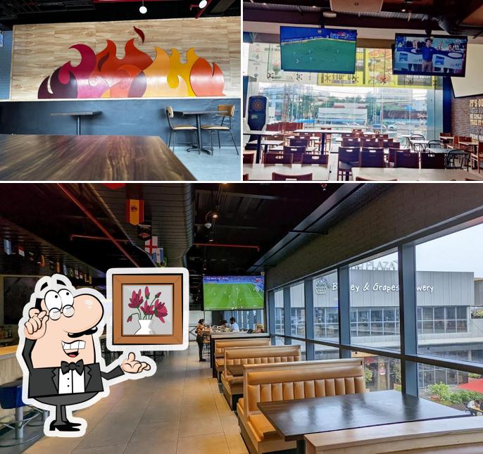 Take a seat at one of the tables at Buffalo Wild Wings (BWW Hyderabad Airport)