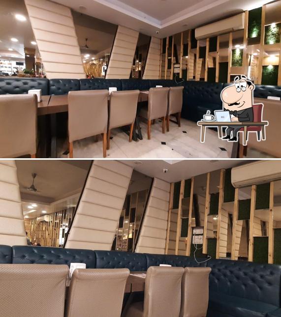 Take a seat at one of the tables at Anupam Sweets & Restaurant