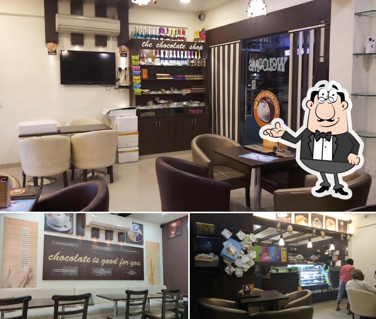 Take a seat at one of the tables at The Chocolate Room - Best Cake Desserts Pizza and Pasta Premium Chocolates Shop in Manjalpur Vadodara