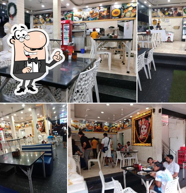 Take a seat at one of the tables at Kanha Pure Veg Family Restaurant (Arpora Road Branch) - best pure veg restaurant in Calangute,veg restaurant goa