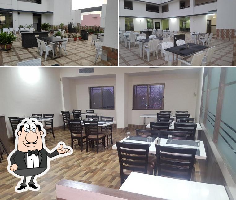 Take a seat at one of the tables at Palkhi RoofTop Veg Restaurant