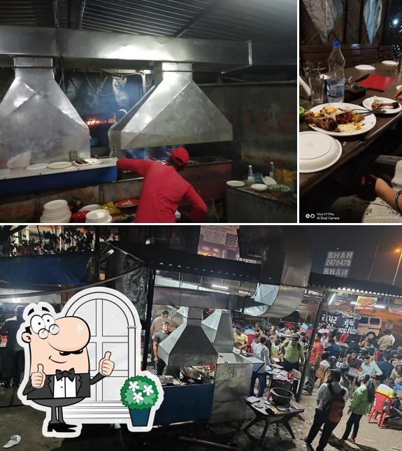 Among various things one can find exterior and dining table at Zam Zam Tawa Fry by greenery