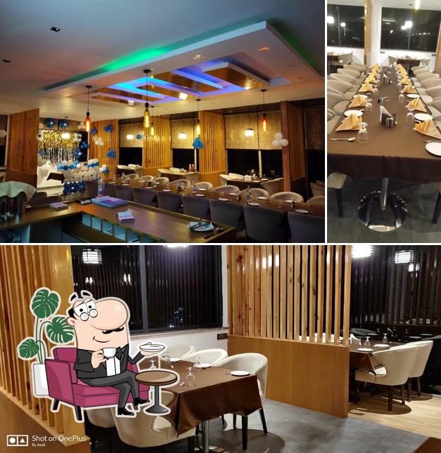 Take a seat at one of the tables at Mokshda Premium Hotel & Restaurant