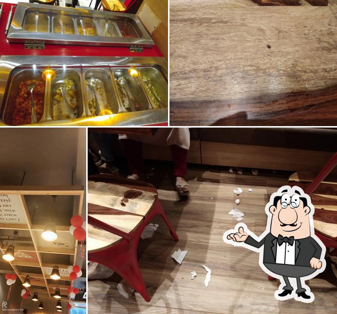 Take a seat at one of the tables at U.S. Pizza Madhapar