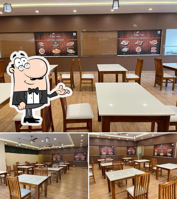 Take a seat at one of the tables at The Indian Rasoi - Pure Veg Restaurant in JP NAGAR