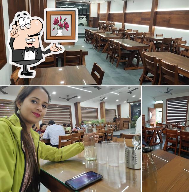 Check out the photo showing interior and dining table at Prakrithi Multi Cuisine Restaurant