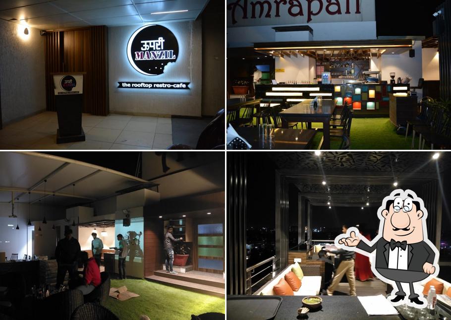 Take a seat at one of the tables at Upri manzil - The Rooftop Restro Cafe