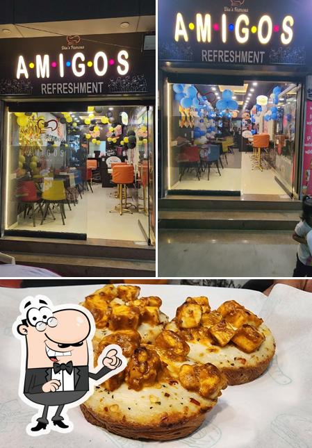 Check out the picture showing interior and food at Amigos Refreshment