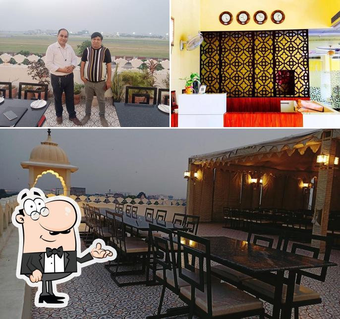 Take a seat at one of the tables at Hawai Chhatri Roof Top Restaurant
