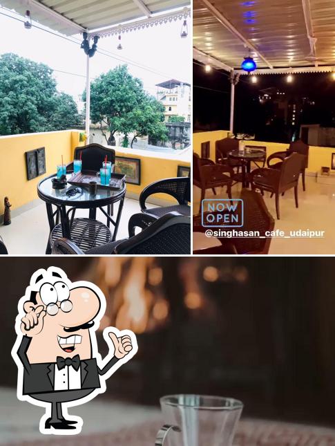 Take a look at the photo showing interior and beverage at Singhasan - The Antique Cafe (Pichola Lake View) Udaipur