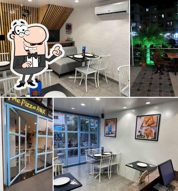 Take a seat at one of the tables at The Pizza Box & Cafe Sinhagad road Pure Veg