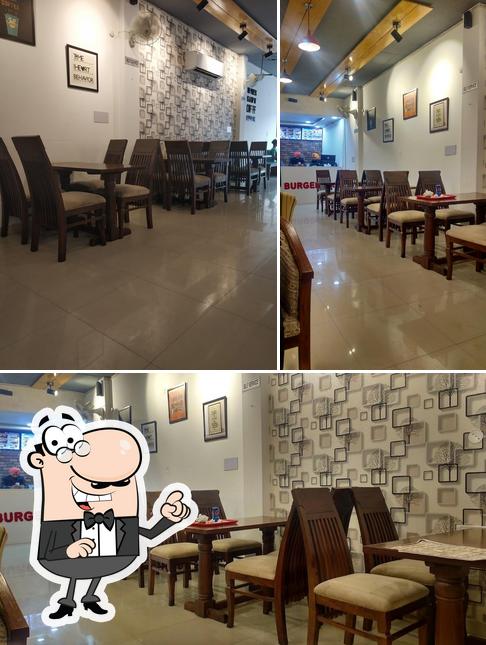 Take a seat at one of the tables at CAFE MG ( Burger Bar & Dominick Pizza )