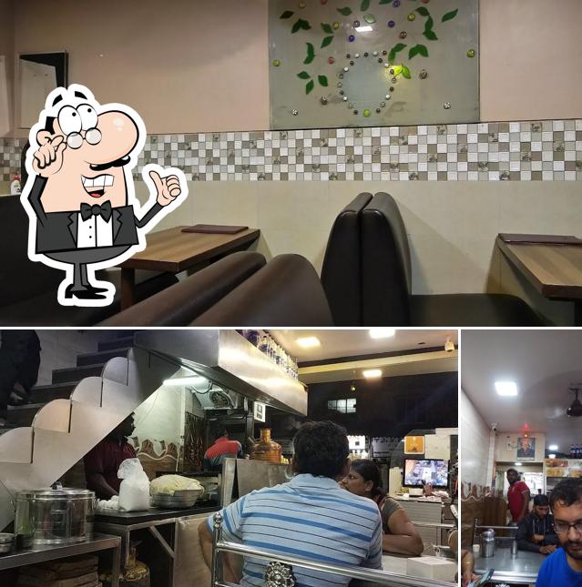 Take a seat at one of the tables at Ayyappan Pure Veg Hotel