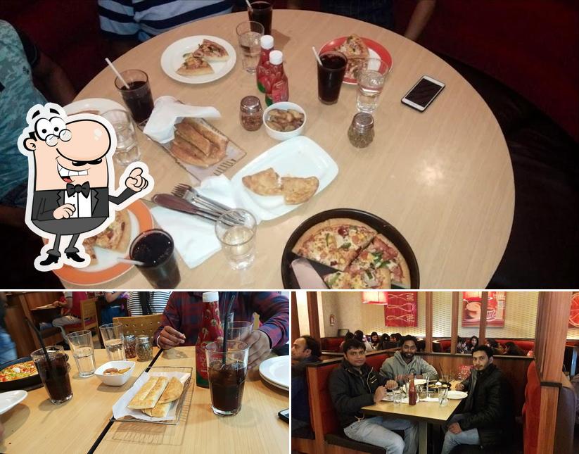 Among various things one can find interior and dining table at Pizza Hut Square Mall, Kanpur