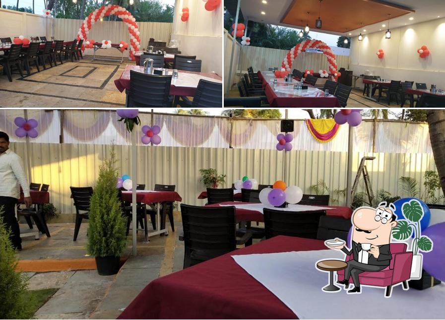Take a seat at one of the tables at Hotel Manyavar Pure Veg Family Garden & Restaurant