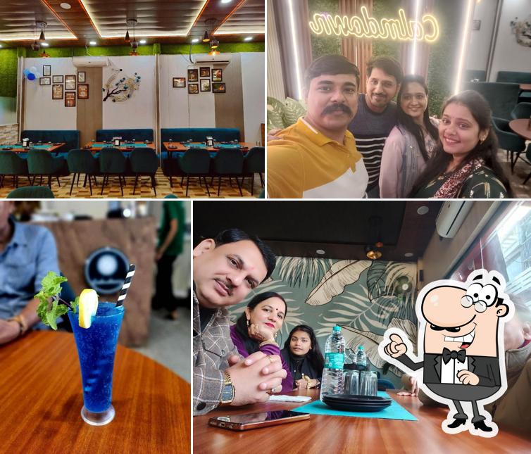 Take a seat at one of the tables at Calmdown Restaurant (Pure Veg)