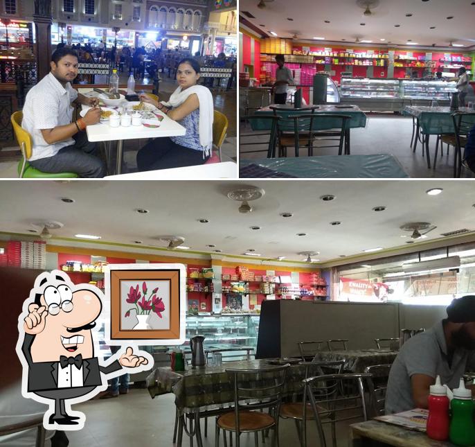 Take a seat at one of the tables at Sudama Sweets and Restaurant