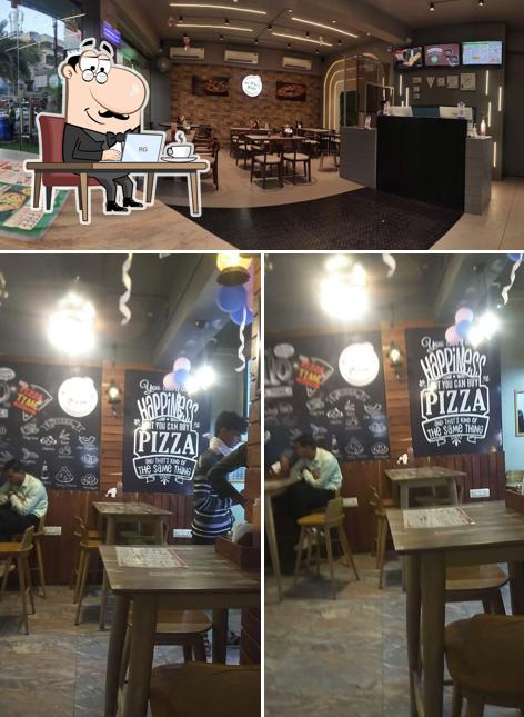 Take a seat at one of the tables at Lapinoz Pizza-Near Lajamni Chowk, Mota Varachha,