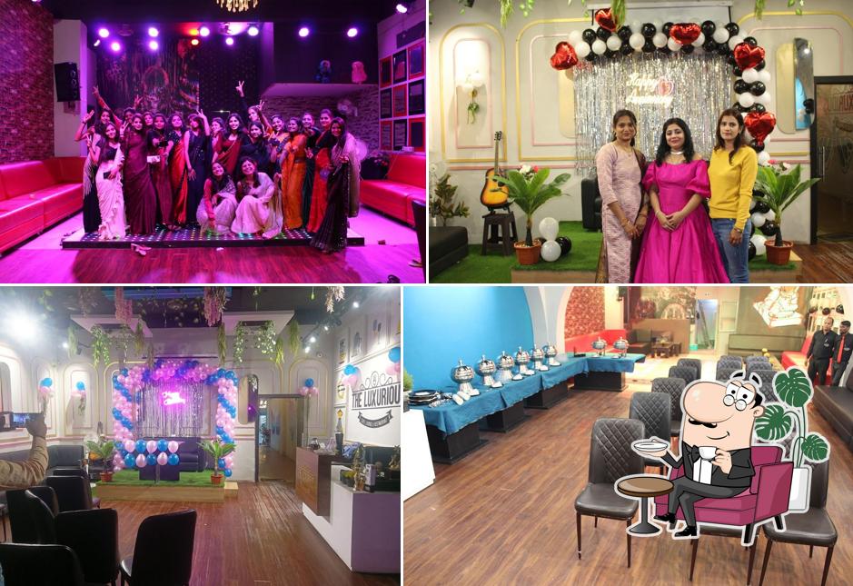 Take a seat at one of the tables at The Luxurious Cafe, Lounge & Restaurant