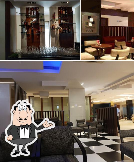 Check out the picture depicting interior and bar counter at The Checkered Bar
