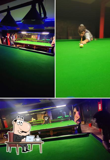 Take a seat at one of the tables at CUE CAN DO SNOOKER CLUB AND CAFE