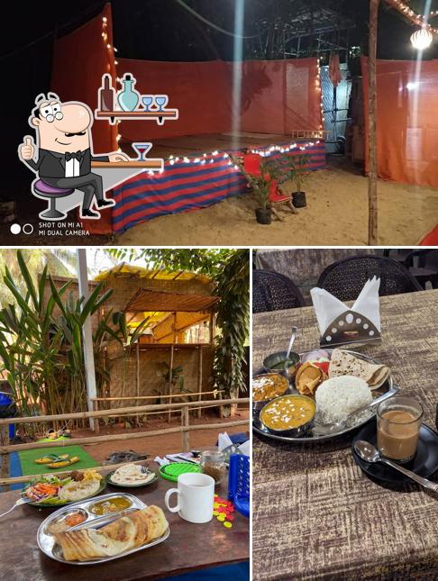 Take a seat at one of the tables at Acoustic Cafe And Wooden Cottages
