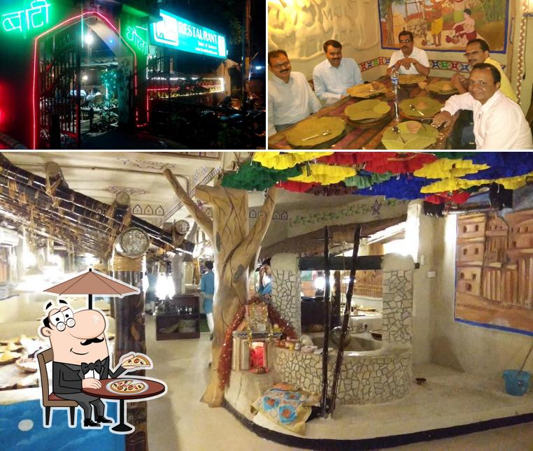 Check out the picture depicting exterior and dining table at Baati Chokha Restaurant (Taste of Banaras)
