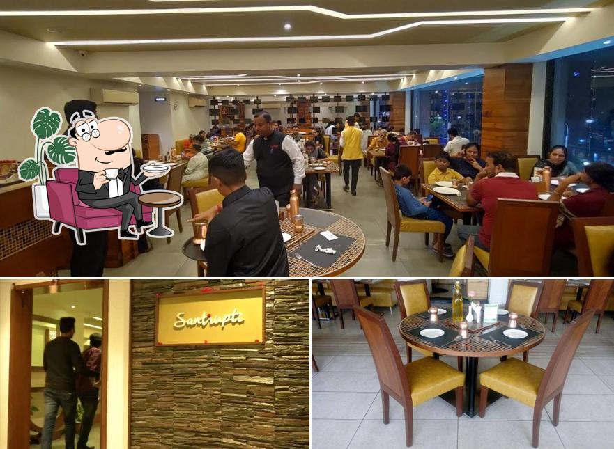 Take a seat at one of the tables at Santrupti Veg Restaurant & Banquet Hall