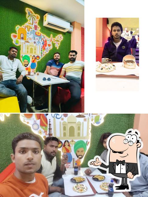 Take a seat at one of the tables at Pizza hub Xpress Tulsipur