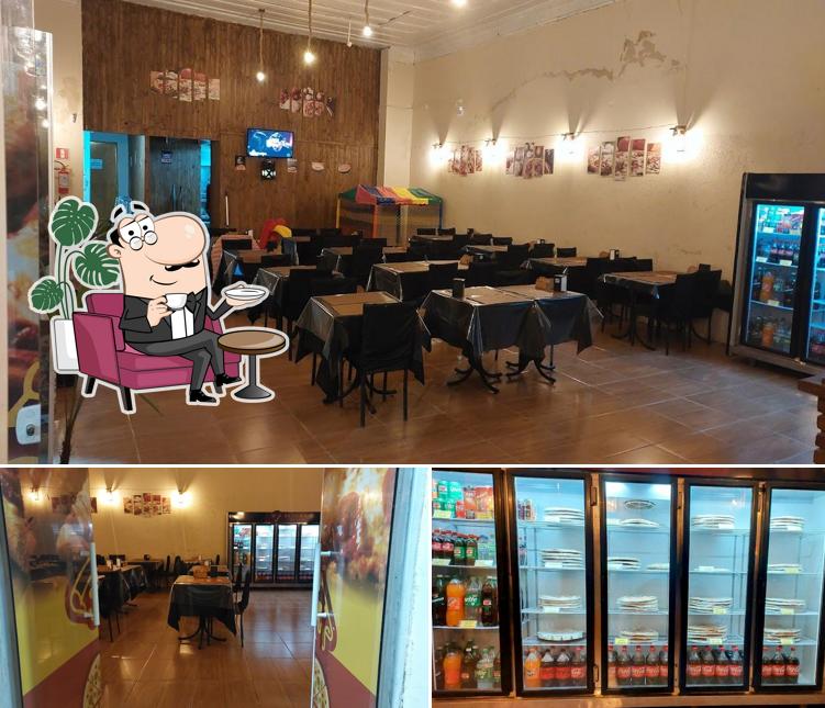 Sente em uma das mesas no Pizzaria Grand Sabor