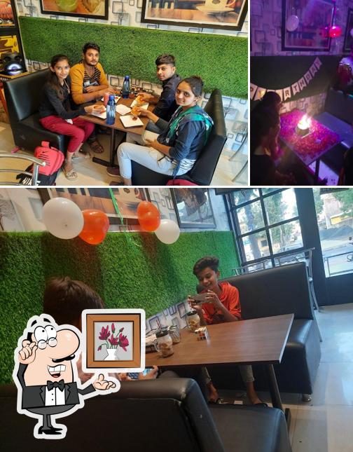Take a seat at one of the tables at HELLY AND CHILLY CAFE - MANSA
