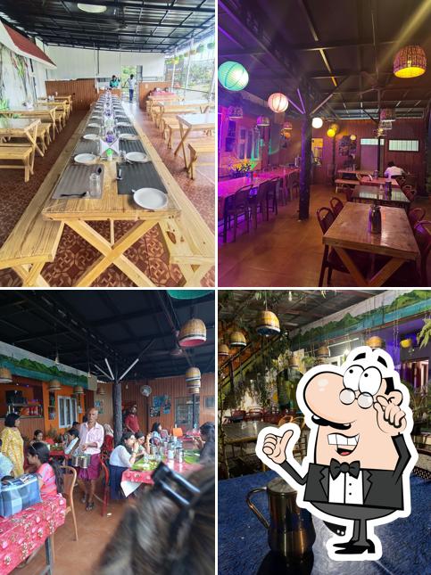 Take a seat at one of the tables at TUSKER CAF'E Restaurant Thekkady