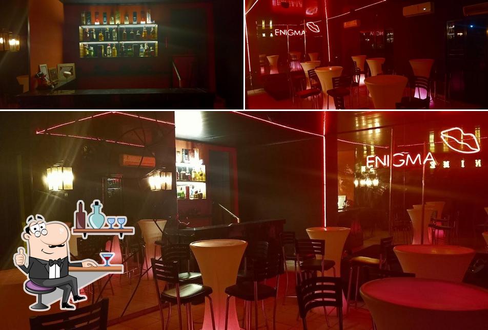 Sente em uma das mesas no ENIGMA DA NOITE BAR E NIGHTCLUB
